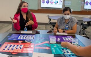 Two female students from Auburn University play Friday Night at the ER tabletop game as an interprofessional activity